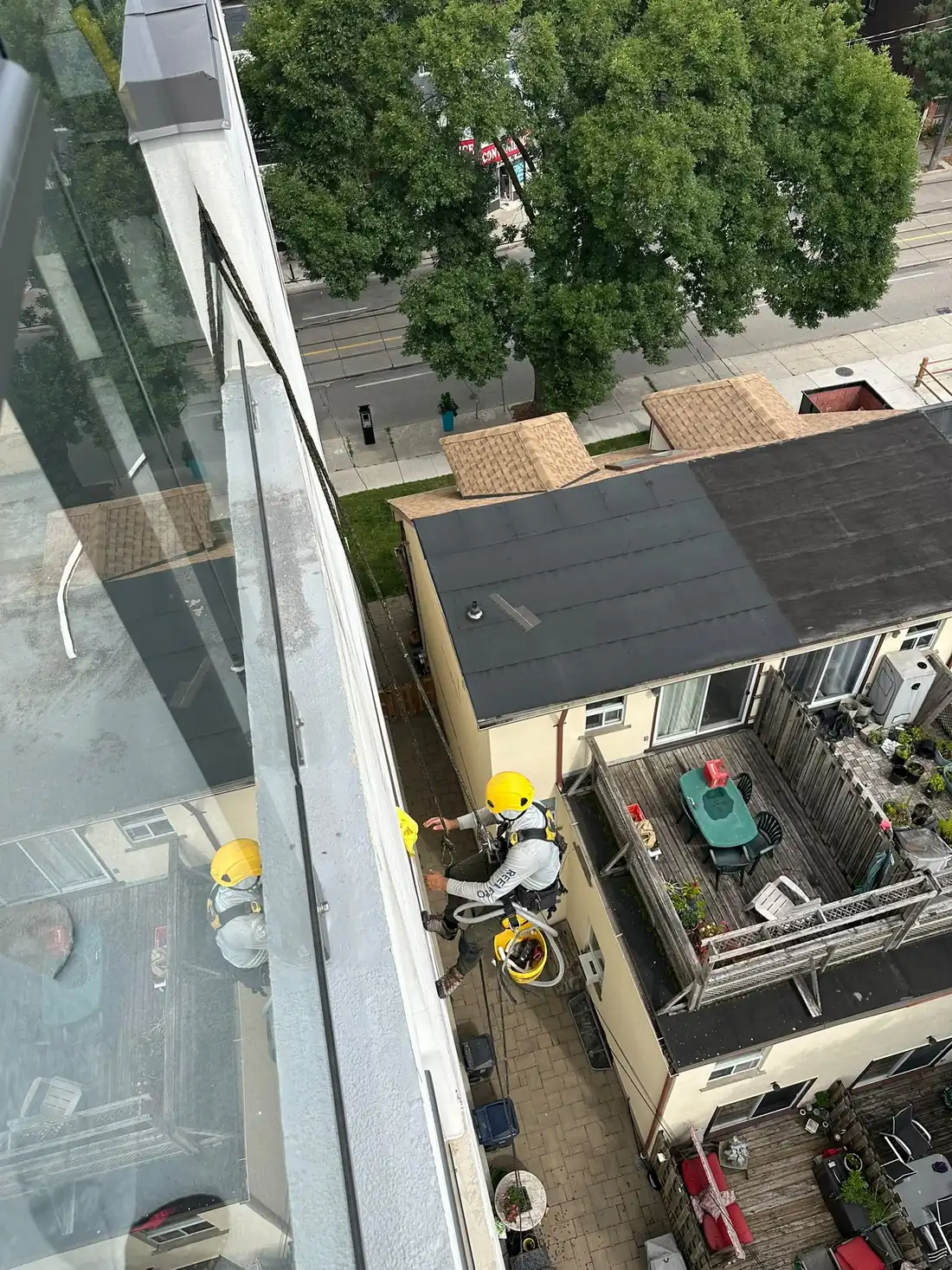 Rope access technician rappelling down a tower face to reach the joints, seen from directly above.