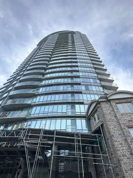 Scaffold erected against a residential tower for envelope and joint work at the lower floors.