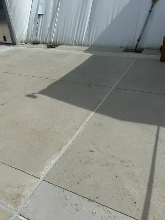 Concrete slab with freshly sealed control joints running through the frame; clean, well-lit detail of joint sealing.